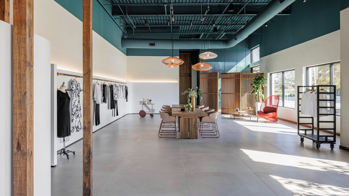 Long view down the showroom with timber columns and natural light
