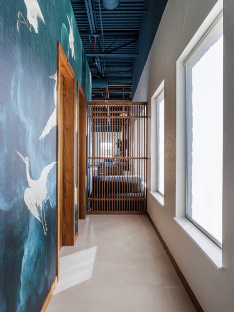Crane mural wall beside a wood slat screen and tall window