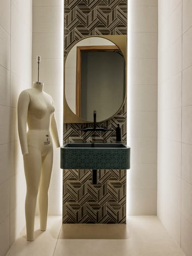 Restroom with oval mirror, patterned tile, and custom green vanity