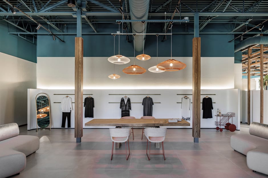 Showroom with pendant lights, wood table, and illuminated display alcoves